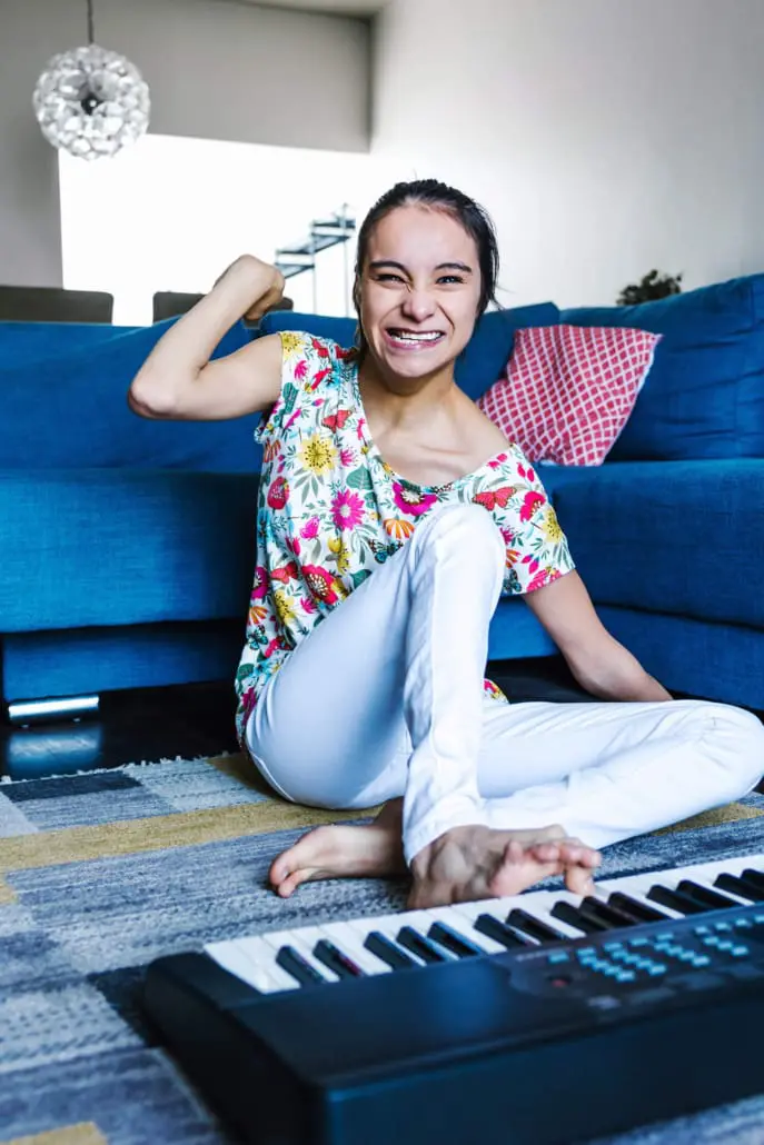 Young woman with a disability playing a keyboard at home